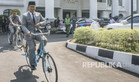 Gubernur Provinsi Jawa Barat terpilih, Ridwan Kamil menaiki sepeda usai diperkenalkan pada Rapat Paripurna Istimewa DPRD Jawa Barat di Gedung DPRD Jawa Barat, Bandung, Jawa Barat, Rabu (25/7).