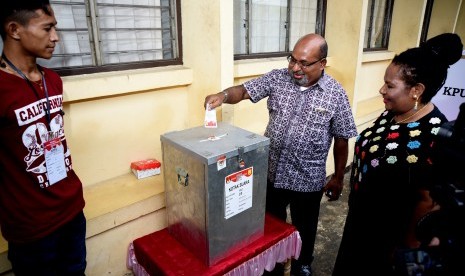 Gubernur Provinsi Papua, Lukas Enembe didampingi istri Yulce Enembe memasukkan surat suara ke kotak suara TPS 23 Jayapura Selatan, Papua, Rabu (15/2).