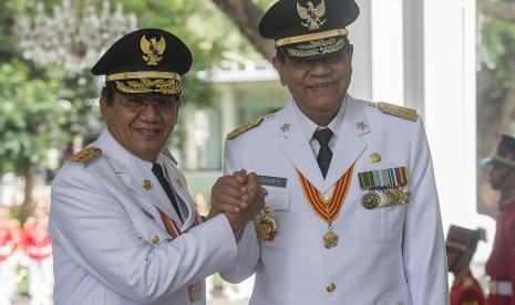 Gubernur Sulawesi Tengah terpilih Longki Djanggola (kiri) berjabat tangan dengan Wakil Gubernur Sulawesi Tengah terpilih Sudarto (kanan) sebelum menerima petikan Keppres di Istana Merdeka, Jakarta. 