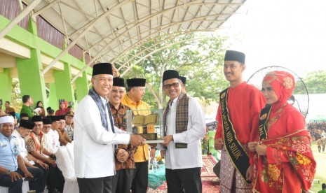 Gubernur Sumatera Barat Irwan Prayitno menyerahkan trofi  MTQ Nasional Tingkat Sumbar edisi 38 kepada juara umum Kabupaten Tanah Datar yang diterima Bupati Irdinansyah Tarmizi di Kota Solok, Jumat (21/6).