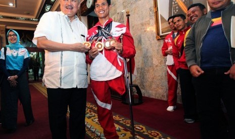 Gubernur Sumatera Selatan, Alex Noerdin, bersama atlet Asean Paragames, Jendi Panggabean, yang meraih lima medali emas dari cabang renang. 