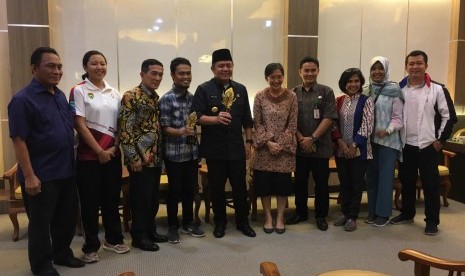 Gubernur Sumatera Selatan (Sumsel) Herman Deru memegang piala juara umum Anugerah Pesona Indonesia (API) 2018 yang diserahkan Kepala Dinas Kebudayaan dan Pariwisata Sumatera Selatan Irene Camelyn bersama tim Disbudpar Sumsel, Jumat (23/11) di ruang tamu Gubernur Sumsel.  