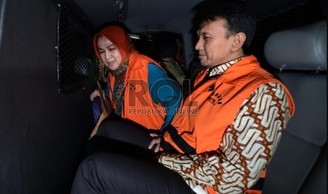 Gubernur Sumatera Utara (nonaktif) Gatot Pujo Nugroho bersama bersama istrinya mudanya Evi Susanti, memasuki mobil tahanan usai menjalani pemeriksaan di gedung KPK, Jakarta, Kamis (20/8). 