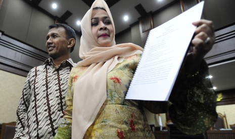 Gubernur Sumatera Utara nonaktif Gatot Pujo Nugroho (kiri) dan istri Evy Susanti (kanan) memperlihatkan naskah nota pembelaan (pledoi) usai mengikuti sidang lanjutan di Pengadilan Tipikor, Jakarta, Rabu (24/2)