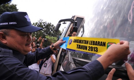 Gubernur Sumsel Alex Noerdin menempelkan stiker angkutan lebaran usai gelar pasukan angkutan lebaran di Terminal Alang-alang Lebar, Palembang, Sumsel, Rabu (31/7).