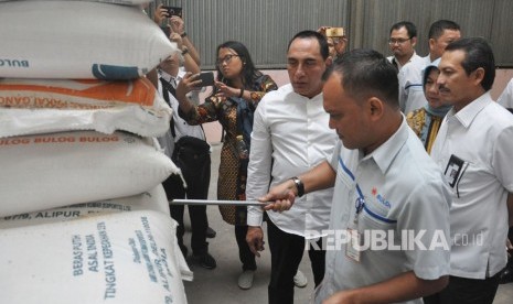 Gubernur Sumut Edy Rahmayadi (tengah) menyaksikan petugas Bulog mengambil sampel beras saat melakukan sidak bahan pangan pokok di gudang penyimpanan Bulog Medan, Sumatera Utara. Bulog Sumut menyebut pembelian beras petani dengan harga komersial