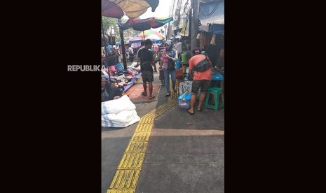 Guide Line di trotoar arahkan penyandang disabilitas pada lokasi berbahaya. Guide line tidak bisa digunakan penyandang disabilitas karena dijadikan lokasi berjualan oleh PKL, Tanah Abang, Jakarta Pusat, Rabu (1/8). 