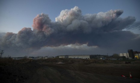 Gumpalan asap hitam kelihatan dari jauh di kawasan terbakarnya lebih dari 100 hektare daerah di Fort McMurray, Alberta, Kanada.