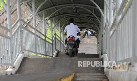 Gunakan JPO. Pengendara motor menggunakan JPO untuk memotong jalan di kawasan Pasar Minggu, Jakarta Selatan, Kamis (19/10)