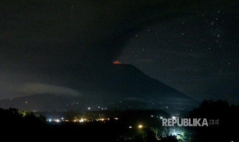 Gunung Agung menyemburkan asap dan abu vulkanis terlihat dari Desa Glumpang, Karangasem, Bali, Ahad (26/11) dini hari.