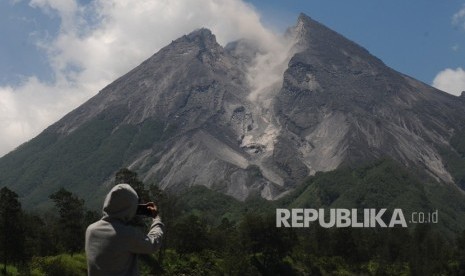 Gunung Merapi. Warga menyaksikan aktivitas guguran awan panas kecil Gunung Merapi di Balerante, Kemalang, Klaten, Jawa Tengah, Selasa (26/2/2019). 