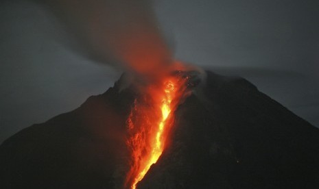   Gunung Sinabung memuntahkan lava panas seperti yang terlihat dari Desa Jeraya, Sumatera Utara, dalam foto yang diambil pada Ahad (5/1).   (AP/Binsar Bakkara)