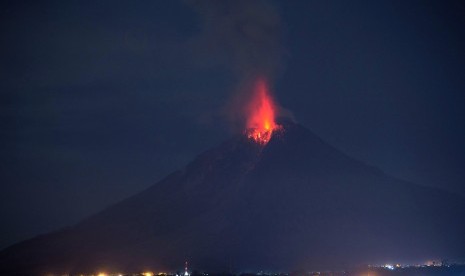 Gunung Sinabung memuntahkan lava pijar tampak dari Bukit Gundaling, Brastagi, Karo, Sumatera Utara, Jumat (18/12) dini hari.