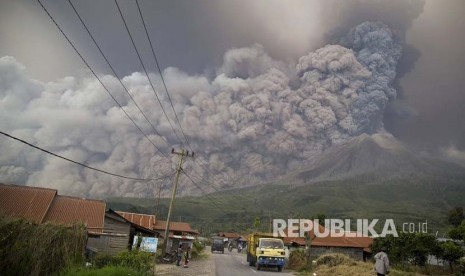 Gunung Sinabung memuntahkan materi  vulkanik tampak dari Kutarakyat, Sumatera Utara.