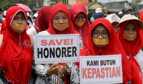 Guru honorer dan guru tidak tetap melakukan aksi tutup mulut saat menggelar aksi di halaman kantor Bupati Blitar, Jawa Timur, Senin (29/10/2018).