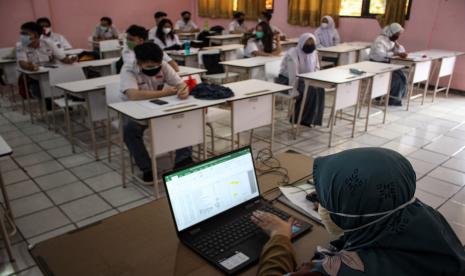 Guru melakukan absensi saat pembelajaran tatap muka terbatas di SMAN 1 Kota Tangerang, Banten.