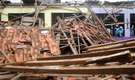 Guru melihat kondisi atap sekolah yang ambruk di SDN Ciheuleut 1 Kota Bogor, Jawa Barat, Selasa (29/3/2022). Dua ruangan kelas di SDN Ciheuleut 1 dan Ciheuleut 2 Kota Bogor tersebut tidak dapat digunakan lagi untuk kegiatan belajar mengajar karena ambruknya bagian atap bangunan akibat konstruksi rangka yang sudah keropos.