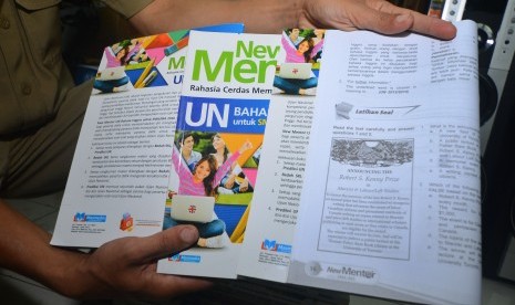 Guru memperlihatkan buku materi Ujian Nasional (UN) mata pelajaran Bahasa Inggris yang didalamnya terdapat gambar bermotif palu arit di SMA Negeri 1 Kawali, Kabupaten Ciamis, Jawa Barat, Senin (23/1). 