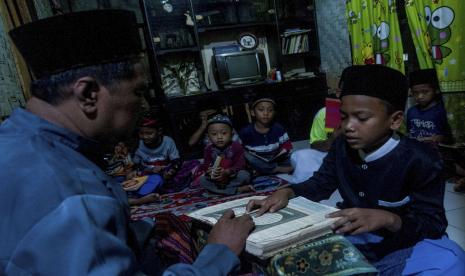 Guru mengajar anak-anak mengaji Alquran.