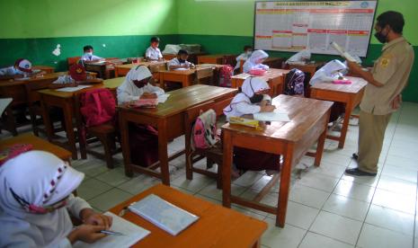 Guru mengajar siswa SD saat pembelajaran tatap muka terbatas di SDN Cihideung Ilir 04, Ciampea, Kabupaten Bogor, Jawa Barat, Selasa (31/8/2021). Pemerintah Kabupaten Bogor mulai membuka pembelajaran tatap muka terbatas tingkat PAUD, SD dan SMP dengan menerapkan protokol kesehatan ketat dan kapasitas 50 persen di masa PPKM level 3.