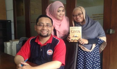 Habiburrahman El Shirazy (kiri) bersama penggemarnya, saat menandatangani novel 