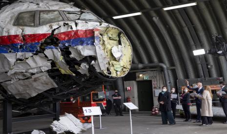 Hakim ketua Hendrik Steenhuis, kanan, menunjuk saat ia dan hakim serta pengacara lainnya melihat puing-puing pesawat Malaysia Airlines MH17 yang direkonstruksi, di pangkalan udara militer Gilze-Rijen, Belanda selatan, Rabu, 26 Mei 2021. Rusia pada Jumat (15/7/2022) melarang outlet berita investigasi Bellingcat dan mitra lokal utamanya beroperasi di dalam negeri.  