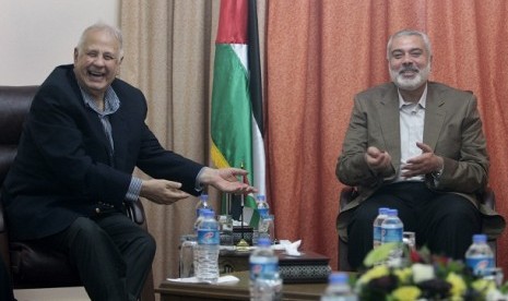 Hamas prime minister Ismail Haniyeh (right) gestures during a meeting with Hanna Nasir, chairman of the Palestinian Central Election Commission (CEC), in Gaza City January 30, 2013. 