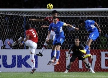 Hamka Hamzah (tengah) berebut bola di udara dengan pesepakbola Filipina Jason Nicolas saat pertandingan leg kedua semifinal AFF Suzuki Cup 2010 di Stadion Utama Gelora Bung Karno Senayan, Jakarta.