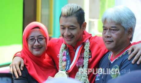 Hanifan Yudani Kusuma, atlet pencak silat peraih medali emas di ajang Asian Games 2018 berfoto bersama kedua orang tuanya saat penyambutan oleh Ikatan Pencak Silat Indonesia (IPSI) Jawa Barat, di halaman GOR Tri Lomba Juang, Jalan Pajajaran, Kota Bandung, Senin (3/9).