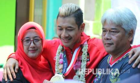 Hanifan Yudani Kusuma, atlet pencak silat peraih medali emas di ajang Asian Games 2018 berfoto bersama kedua orang tuanya saat penyambutan oleh Ikatan Pencak Silat Indonesia (IPSI) Jawa Barat, di halaman GOR Tri Lomba Juang, Jalan Pajajaran, Kota Bandung, Senin (3/9).