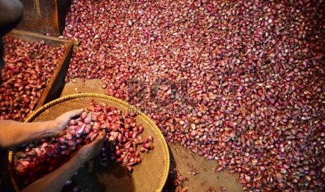 Pedagang memilah bawang merah di Pasar Senen, Jakarta.