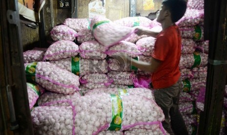 Pedagang memilah bawang putih di Pasar Senen, Jakarta Pusat.