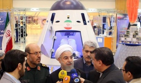 Hassan Rouhani saat meninjau model pesawat antariksa Iran