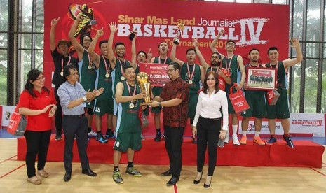 Head of Corporate Communication Sinar Mas Land Panji Himawan memberikan trofi juara Sinar Mas Land Journalist Basketball Tournament (SMLJBT) 2016 kepada salah satu pemain Trans TV, Kamis (1/12).