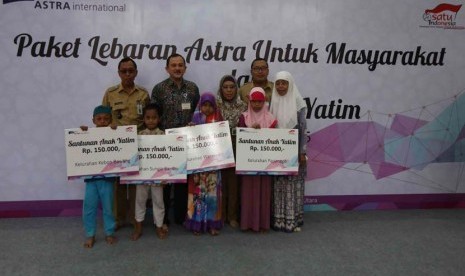 Head of Environment & Social Responsibility PT Astra International Tbk Riza Deliansyah menyerahkan secara simbolis santunan sebesar Rp 150.000 kepada anak yatim didampingi Lurah Sungai Bambu Sumarno (paling kiri) dan Lurah Warakas Sri Hartati (kedua kanan)