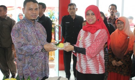 Head of Regional Jabar JNE Hardiana Apriliyanti (kanan) menyerahkan potongan tumpeng kepala Branch Manager JNE Karawang Syamsuri sebagai tanda peresmian Kantor Perwakilan JNE Karawang Barang, belum lama ini.