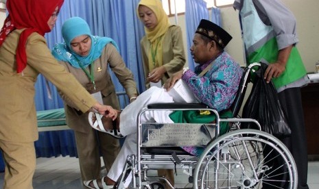 Health workers examine a hajj pilgrim (sitting in wheel chair) in Bekasi, West Java, on Wednesday, September 11, 2013.