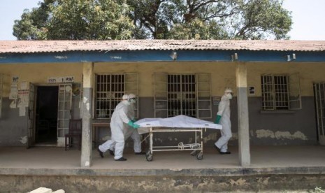 Health workers push a gurney with a dead body at a Red Cross facility in the town of Koidu, Kono district in Eastern Sierra Leone December 19, 2014.