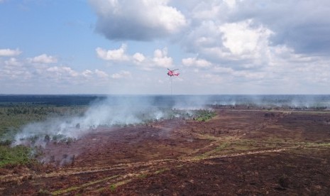 Heli jenis Superpuma Asia Pulp Paper (APP) Sinar Mas Forestry melakukan waterbombing di Teluk Meranti, Pelalawan, Riau.