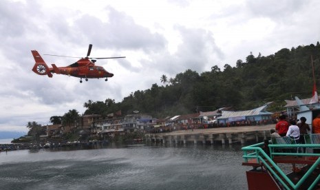 Helikopter Basarnas jenis Dauphin HR-3604 bersiap mendarat di Pelabuhan Tigaras, Danau Toba, saat melaksanakan pencarian korban tenggelamnya KM Sinar Bangun, di Simalungun, Sumatera Utara, Sabtu (23/6). 