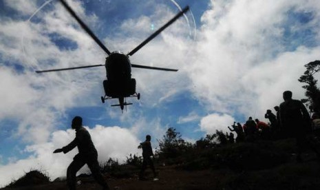 Helikopter dibantu petugas TNI dan sejumlah relawan bersiap mengevakuasi korban jatuhnya pesawat Sukhoi Superjet 100 di Puncak I Gunung Salak, Kabupaten Bogor, Jawa Barat, Ahad (13/5)