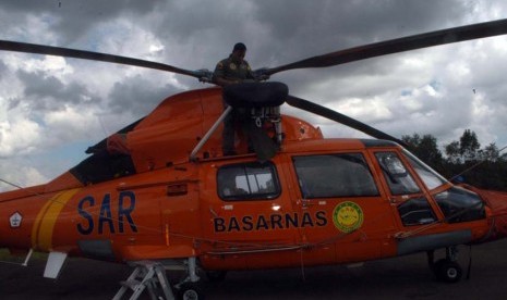 Helikopter jenis Dolphin milik Basarnas ditutupi terpal oleh petugas di posko utama Lanud TNI AU Iskandar, Pangkalan Bun, Kotawaringin Barat, Kalimantan Tengah, Rabu (28/1).  (Republika/Rusdy Nurdianysah)