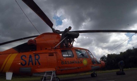 Helikopter jenis Dolphin milik Basarnas ditutupi terpal oleh petugas di posko utama Lanud TNI AU Iskandar, Pangkalan Bun, Kotawaringin Barat, Kalimantan Tengah, Rabu (28/1).  (Republika/Rusdy Nurdianysah)