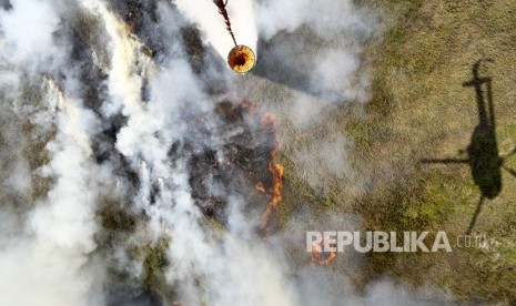 Helikopter MI-172 milik Badan Nasional Penanggulangan Bencana (BNPB) melakukan pemadaman kebakaran lahan dari udara water boombing di Tulung Selapan, Ogan Komering Ilir (OKI), Sumatera Selatan, Ahad (22/7). 