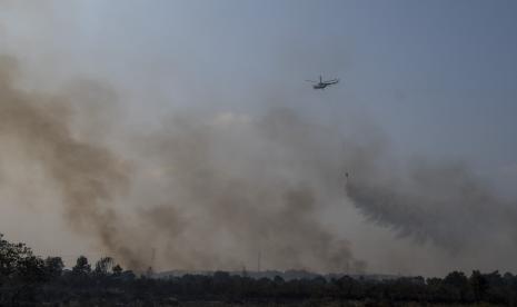 Helikopter Mi-8AMT melakukan pemadaman kebakaran hutan dan lahan dari udara (water bombing). Ilustrasi.