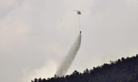 Helikopter Water Bombing  MI 8 milik BNPB memadamkan titik api dari udara, di wilayah Dusun Ngaduman, Desa Batur, Kecamatan Getasan, Kabupaten Semarang, Rabu (17/10). Upaya pemadaman api yang membakar hutan kawasan lereng Merbabu mulai mendapatkan dukungan dari udara.