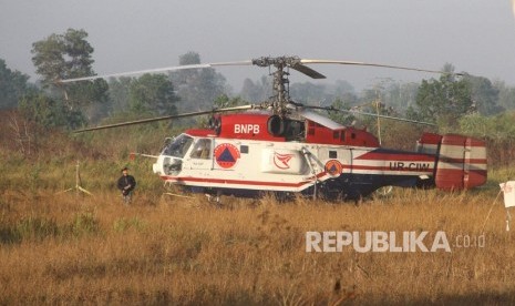 Helikopter water bombing milik BNPB mendarat darurat di areal persawahan di kawasan Cempaka Banjarbaru, Kalimantan Selatan, Jumat (13/9/2019).