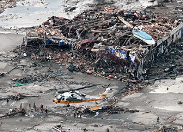 Helikopter Angkatan Udara Jepang berusaha mendarat di dekat bangunaan yang porakporanda di  Minamisanrikucho, Prefektur Miyagi, Sabtu (12/3)  