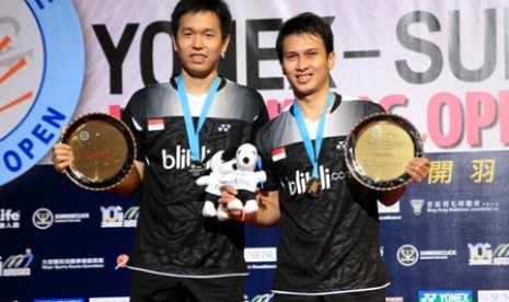 Hendra Setiawan (kiri) dan Mohammad Ahsan berpose dengan trofi juara Hong Kong Open Super Series, Ahad (23/11).