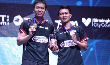 Hendra Setiawan/Mohammad Ahsan menunjukkan medali juara All England 2019.